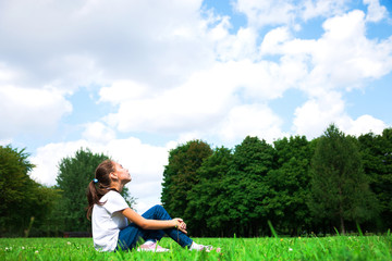 girl sitting on the grass in the Park and resting
