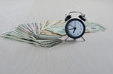  business financial ideas concept with banknotes stack and alarmclock. time is money. time is worth the money. time is more valuable than money. copy space. soft focus
