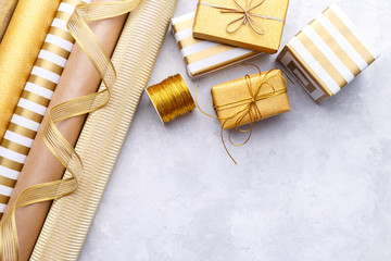 Golden glossy wrapping paper rolls and gift boxes