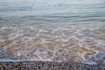 Sea wave in the morning light. Sea wave and beach. Sea wave background. Crimea. Wave and pebble beach. Rest and travel to the sea.