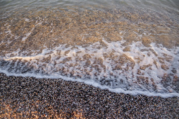 Sea wave in the morning light. Sea wave and beach. Sea wave background. Crimea. Wave and pebble beach. Rest and travel to the sea.