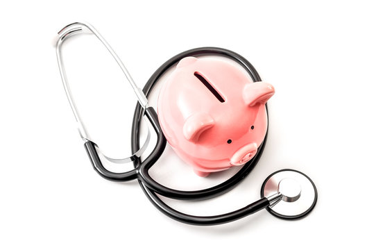 Healthcare cost and the high price of quality health care insurance concept theme with a stethoscope and a pink piggy bank isolated on white background