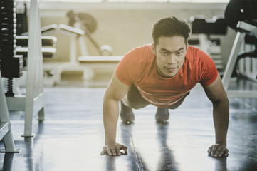 Portrait of Asian man being physically Push-up in the gym.
