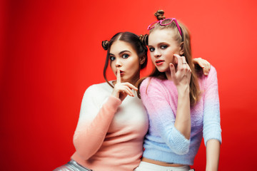 two best friends teenage girls together having fun, posing emotional on red background, lifestyle people concept