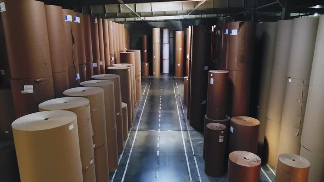motion along aisle between packaging paper rolls in storage
