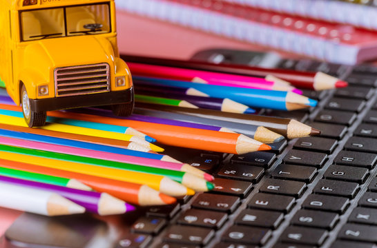 Back to school , school bus on colored pencils and keyboard