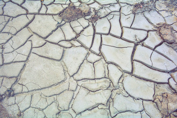 Dry mud ground, crack texture, granite gravel. Dry dirty soil. Cracks on clay