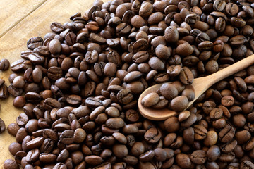 rustic spoon over coffee beans on wooden table