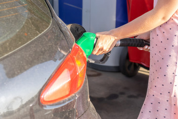 Young woman refilling petrol in gas station 