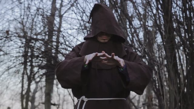 Dark Shaman In Monastic Robes Conjures In The Forest