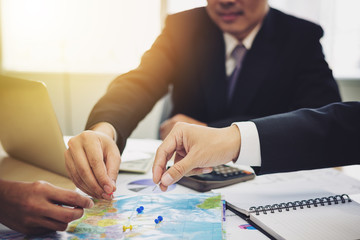Three  businessmen is pointing at the map with the pins in business meeting. They are brainstorming about the target of customer in terms of marketing.