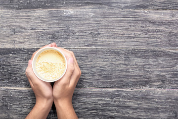 Hand holding a styrofoam cup of hot coffee
