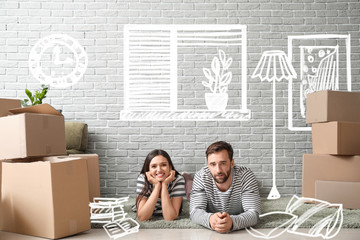 Happy couple with belongings imagining interior of new house