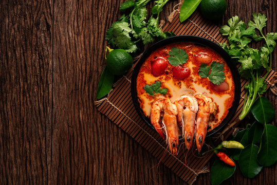 Tom Yum Goong spicy soup traditional food cuisine in Thailand on wooden background , top view, copying area, national food