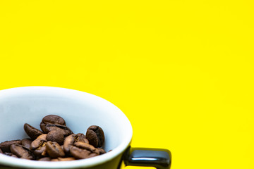 cup with coffee beans and colored paper background