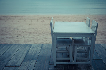 Fototapeta na wymiar Vintage tone of White table for dinner on the beach and sky