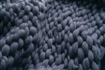Merino wool handmade knitted large blanket, super chunky yarn, trendy concept. Close-up of knitted...