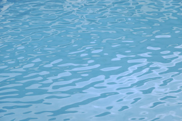 Blue swimming pool edge with refection of water ripple