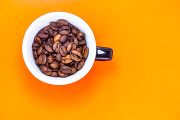 cup with coffee beans and colored paper background