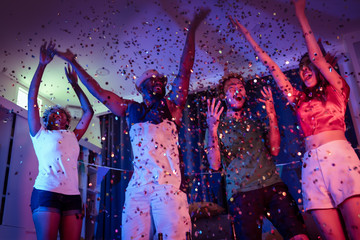 emotion of friend celebrating and having fun and celebrate dancing party by raised hands up cheers together in the dark night neon color light environment background at home