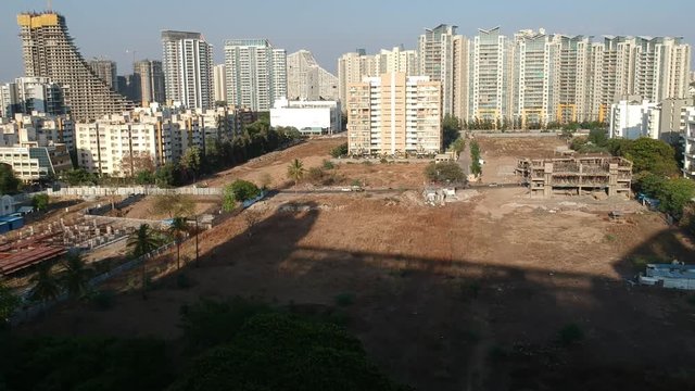 Aerial footage shot in a growing Indian city showcasing architectural buildings as well as new residential apartments.