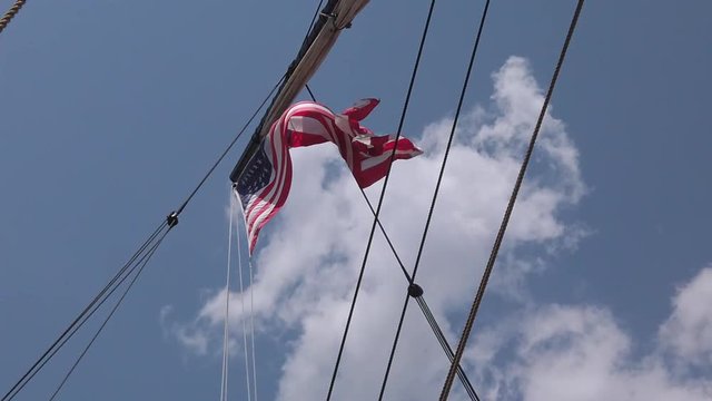 Flag waving in slow motion on mast of tall ship
