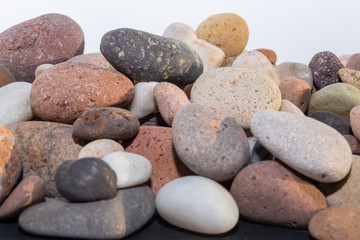 Fototapeta na wymiar piedras pequeñas de colores con desgaste de playa hermosa, con algunos caracoles marinos y sedimentos 