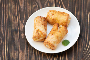 Cottage cheese biscuits (triangles, angles) with sugar. Homemade buns stuffed with cottage cheese on a wooden background. Selective focus.