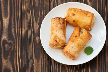 Cottage cheese biscuits (triangles, angles) with sugar. Homemade buns stuffed with cottage cheese on a wooden background. Selective focus.
