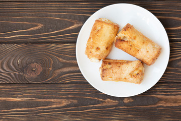 Cottage cheese biscuits (triangles, angles) with sugar. Homemade buns stuffed with cottage cheese on a wooden background. Selective focus.