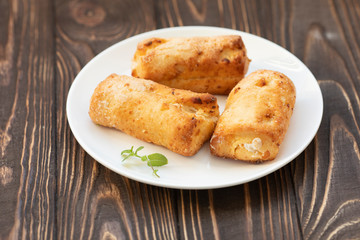 Cottage cheese biscuits (triangles, angles) with sugar. Homemade buns stuffed with cottage cheese on a wooden background. Selective focus.
