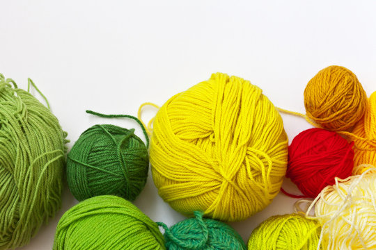 Needlework. Colorful  balls of yarn for hand knitting on a white background. On top empty space for text. Flat lay, close up. Crafts and Hobbies