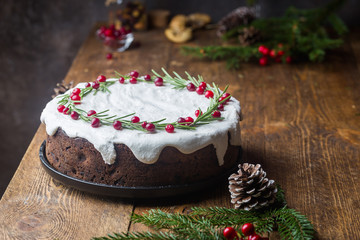 Traditional Christmas cake with fruits, nuts and white glaze with Christmas decorations