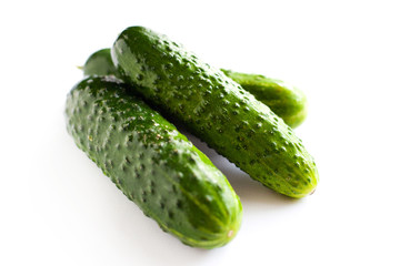 small gherkins, delicious fresh cucumbers on a white background 