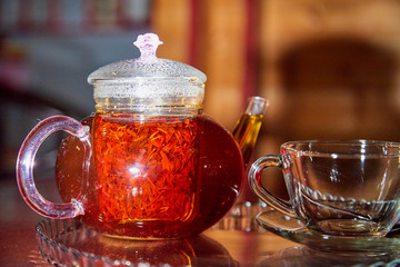 Teapot and cup with light behind them and black background. Hot drink concept