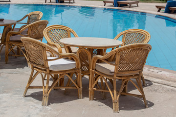 Rattan table and chairs in beach cafe near swimming pool next to the red sea in Sharm el Sheikh, Egypt