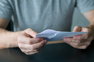 Written communication. Cropped shot of man taking out received letter from envelope. Copy space.