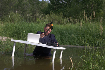 Young bearded millennial man tired of office work Doing stupid things in the workplace.