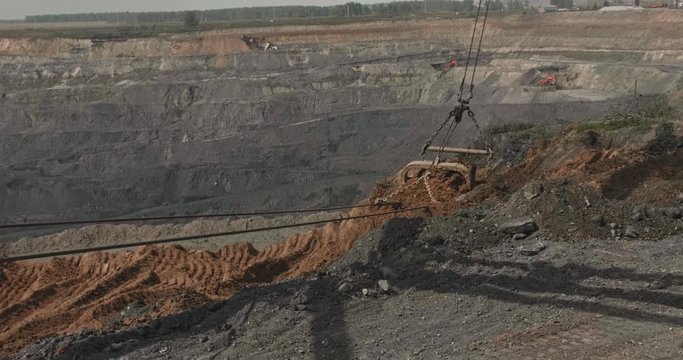 Dragline excavator loads soil, clay. Work walking excavator in open pit. Working heavy machinery in quarry. Open development