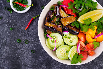 Salad fresh raw vegetables - armenian cucumber, tomatoes, paprika, parsley, red onion and stewed eggplant. Vegan buddha bowl. Top view