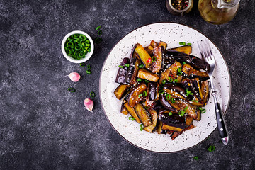 Hot spicy stew eggplant in Korean style with green onion. Aubergine saute. Vegan food. Top view