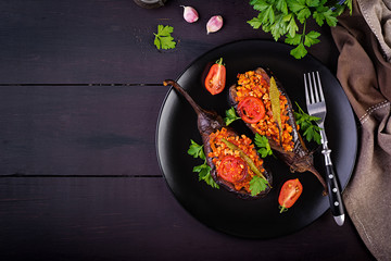 Karniyarik - turkish traditional aubergine eggplant meal. Stuffed eggplants with ground beef and vegetables baked with tomato sauce. Turkish cuisine. Top view. Copy space
