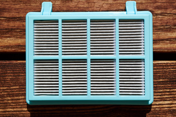 vacuum cleaner hepa filter with fiberglass in blue plastic case on the woodeb floor