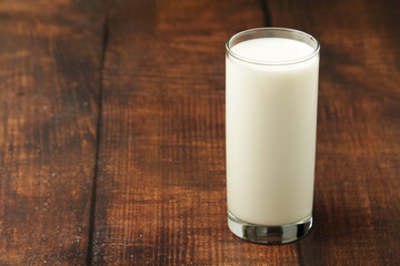 A glass with milk on a wooden rustic table	