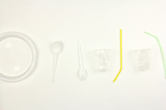 Different White Used Dirty Plastic Disposable Tableware, Plate Fork Spoon Cup And Straw, On White Background, Garbage Environmental Problem