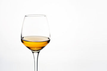 Glass of white wine on white background close-up