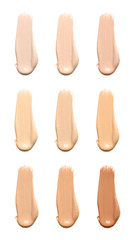 Set with smears of different foundations on white background
