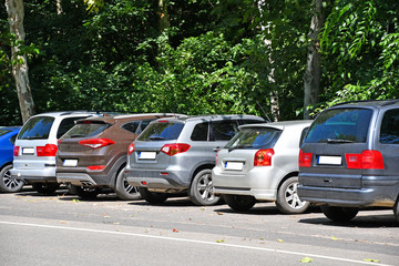 Obraz na płótnie Canvas Cars in the parking lot near a woods