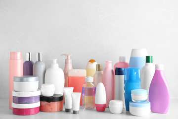Different body care products on table against light background