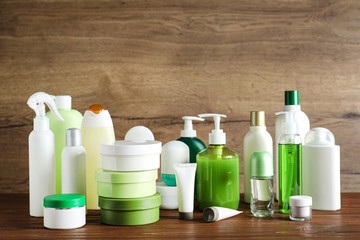 Different body care products on table against wooden background